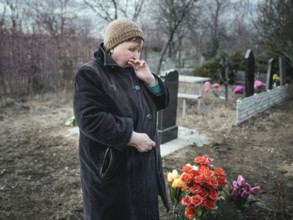 Ludmilla (68) mourns her grandson, who died at the front a month earlier, at the cemetery. The