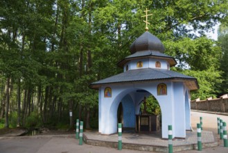 A small blue Orthodox chapel with a dome and icons in the forest, Well of the Holy Spring,