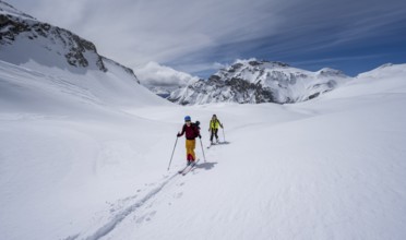 Ski tourers in a mountain landscape with snow, summit Wildhorn in the background, ascent to