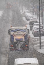 Winter weather, heavy snowfall, city centre traffic, winter service vehicle from