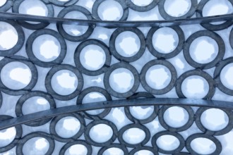 Surface of metal rings, partially covered with snow, detail of the art installation Wunderhorn by