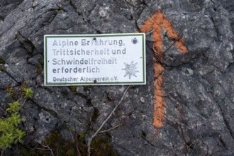 Warning sign on a rock on a hiking trail, Alpine experience and a head for heights required, hiking