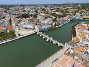 Landscape with river and bridge, surrounded by a town with Mediterranean buildings and urban flair,