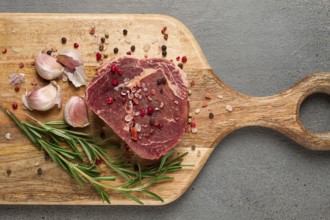 Fresh, raw rib eye steak, on a chopping board, top view, no people