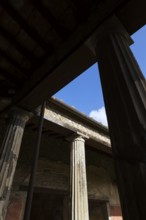 Large old building with silhouetted stone columns at the ancient ruins of Pompeii, Campania region,