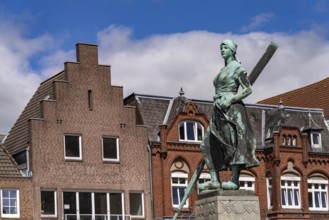 Tine statue of the Asmussen-Woldsen monument or Tine fountain in front of the houses of the old