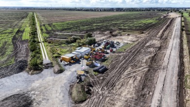 Construction vehicles are parked on an access road under construction to the High Tech Park at the