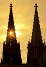 The sun shines through one of the two towers of Cologne Cathedral, Cologne, Rhineland, North