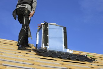 Roofer works on the chimney cladding