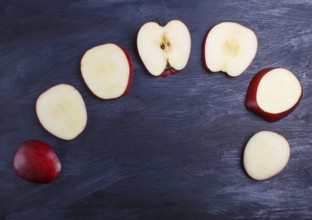 Sliced red apple on black wooden background. closeup. top view, copyspace