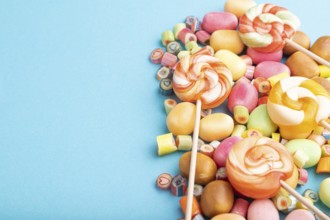 Various caramel candies on blue pastel background. copy space, side view