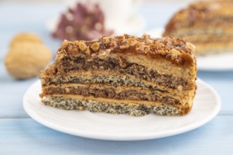 Walnut and hazelnut cake with caramel cream, cup of coffee on blue wooden background. side view,