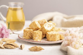 Traditional turkish delight (rahat lokum) with glass of green tea on a gray concrete background and