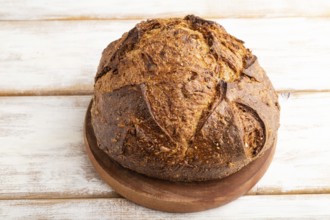 Fresh homemade golden grain bread with wheat and rye on white wooden background. side view, close