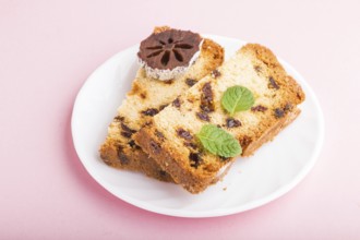 Homemade cake with raisins and dried persimmon on a pink pastel background. Side view, close up,