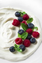 Breakfast, yogurt with fresh berries, raspberries and blueberries, on a white background, selective