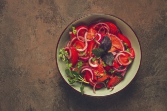 Fresh tomato salad, with red onion, spices and herbs, top view, close-up, homemade