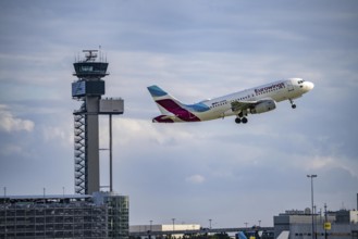 Eurowings Airbus A319-100 taking off at Düsseldorf International Airport, air traffic control tower