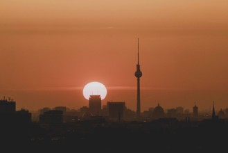 The sunrise emerges behind the city skyline with the television tower in Berlin, 04/09/2024