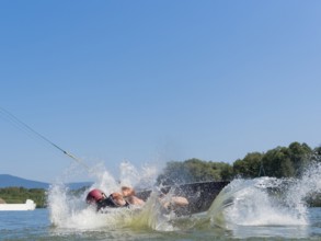 Man makes somersault with wakeboard, fall, water ski and wakepark