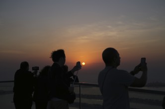 Tourists take selfie with smartphone, selfie stick, The View At the Palm, Palm Jumeirah, sunset,