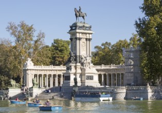 Rowing boats in boating pond of Estanque, El Retiro park, Madrid, Spain, monument to King Alfonso