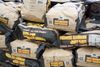 Piled bags of mesquite lump charcoal, UK