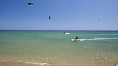 Kitesurfer on turquoise blue sea near the beach under a clear blue sky, surfers paradise,