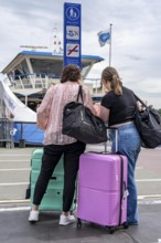 Tourists with luggage, wheeled suitcases, at Amsterdam Centraal railway station, Netherlands