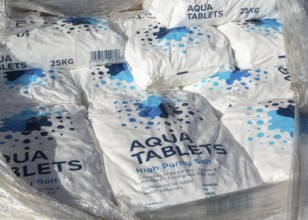 Piled 25kg bags of Aqua Tablets high purity salt tablets for water softeners, UK