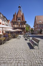 Market square with historic town hall, benches and outdoor area of a café in Michelstadt, Odenwald,