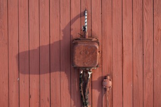 Old electrical junction box from Siemens, red painted wooden wall, Ny-Ålesund, Kongsfjord,