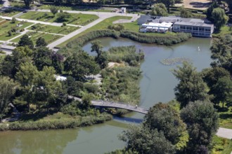 A green park with a bridge and river surrounded by lush vegetation, Vienna