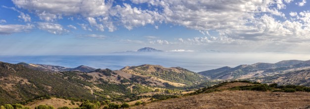 Panoramic view of hilly landscape by the sea under a blue sky, near Tarifa, view to Morocco