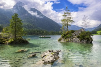 Hintersee near Ramsau with clear green water, surrounded by forests and mountains under a cloudy