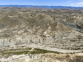 Wide valley in dry mountain landscape with sparse vegetation, aerial view, Tabernas Desert,