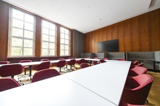 Modern conference room with large windows, wooden walls and red chairs, University of Stuttgart,