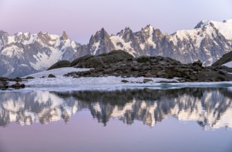 Evening mood with pink evening sky, mountain landscape at sunset, water reflection in Lac Blanc,