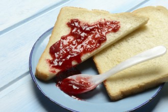 Toast with raspberry jam on a plate, breakfast