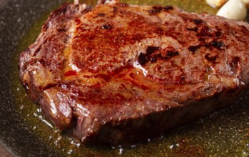 Fried steak, beef steak, rib eye steak, in a frying pan, top view, no people