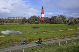 Cyclist in front of the lighthouse from 1906, island of Pellworm, Schleswig-Holstein Wadden Sea