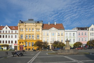 Urban street with historic buildings and a fountain under a clear sky, Ceská Lípa, Bohemian Leipa,