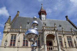 Modern art in front of Brabantine Gothic town hall in the city Damme in summer, West Flanders,