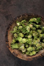 Fresh, green hazelnuts, close-up, in a wooden bowl, unpeeled, top view, no people