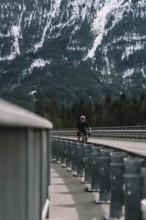 Road bike rider in spring in the Allgäu against the picturesque backdrop of the Alps, Bavaria,