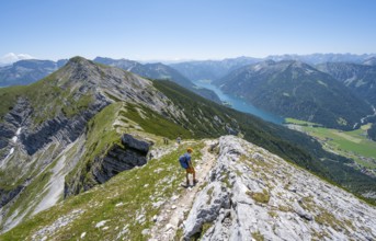 Mountaineer on the hiking trail on the summit ridge of the Unnütz, behind Achensee and summit of