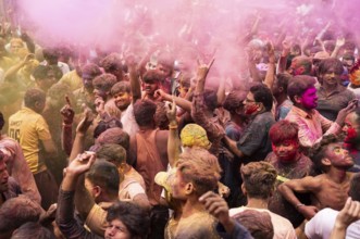 Revellers dancing in the beat of music as they celebrate Holi on a street, the Hindu spring