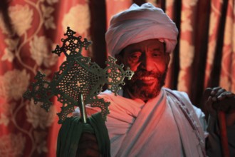 Rock churches of Lalibela, in the Church of the Cross, Bete Maskal, pilgrims, priest with cross,