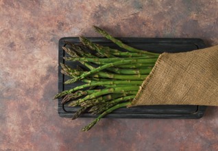 Bouquet of fresh asparagus, on an abstract background, top view, rustic, no people