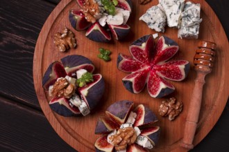 Appetizer, Figs with blue cheese, walnut, honey, on a wooden board, top view, close-up, no people